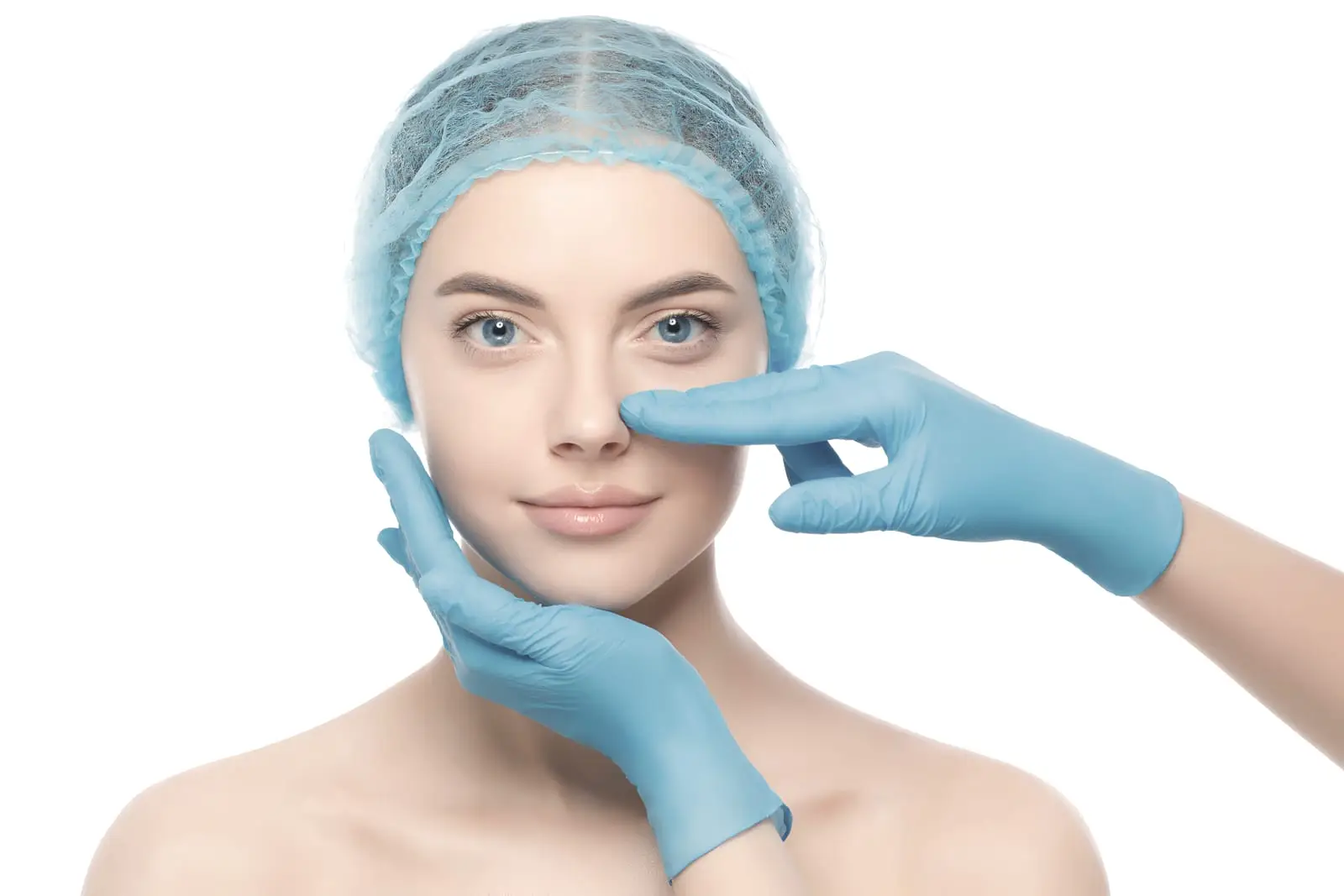 A woman in a surgical cap facing the camera while two gloved hands rest either side of her nose, as they would during an examination.