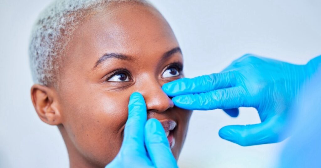 A doctor checking woman's for a nose job or rhinoplasty.