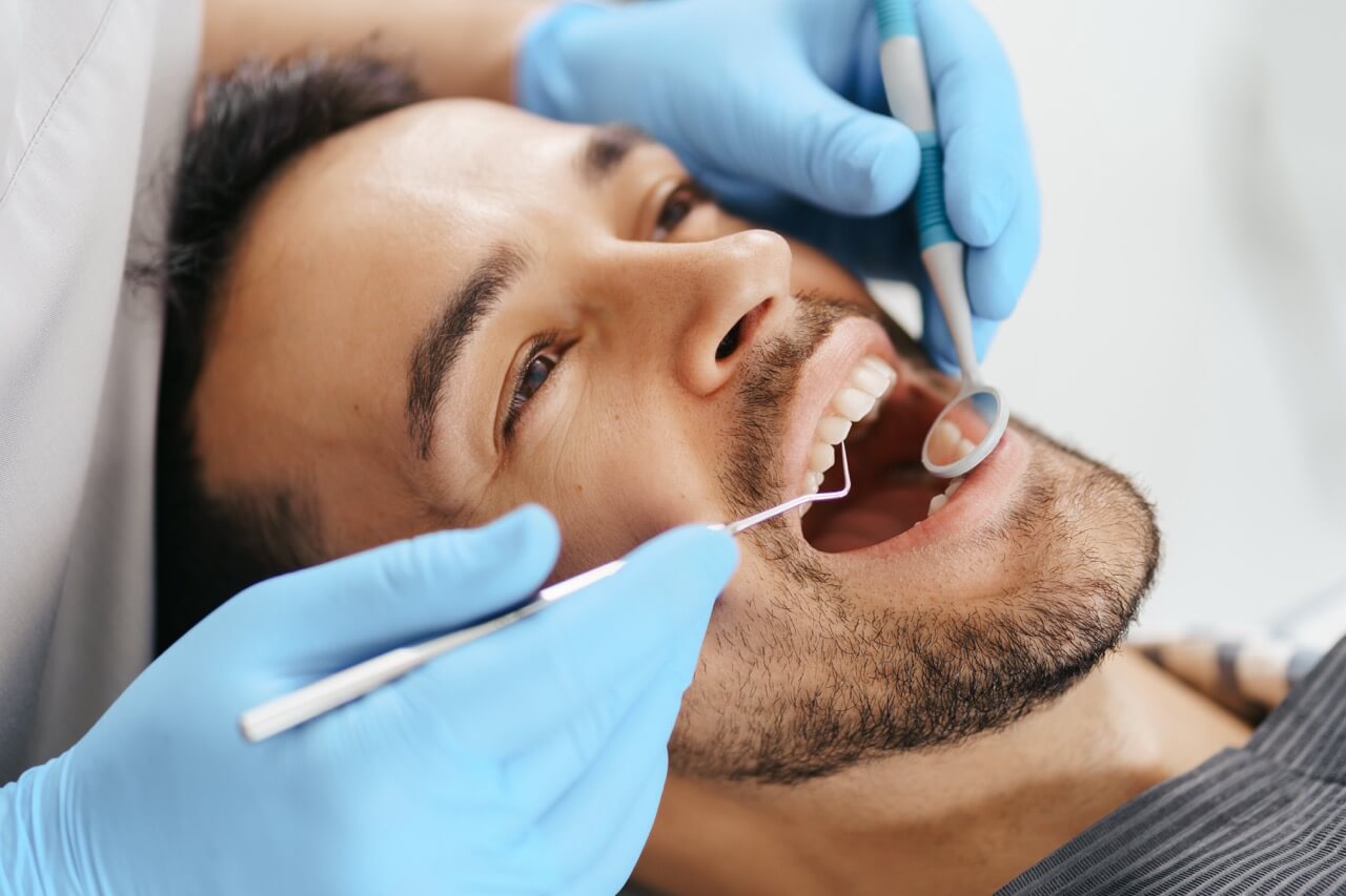 A dentist checking the man's teeth.